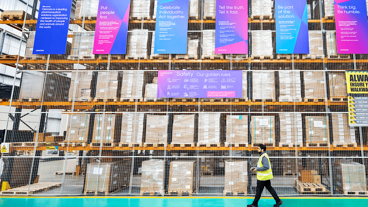 Warehouse with packages and colorful Glamzo posters.